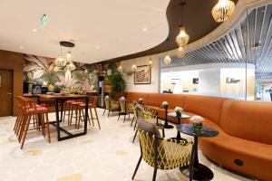 a lobby with a couch and tables and chairs at 080 Transit Hotel, T2 in Bangalore