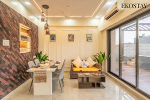 a living room with a table and a couch at EKOSTAY - Kara Villa in Karjat