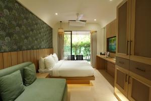 a bedroom with a bed and a couch in it at Bougainvillea in Nagaon