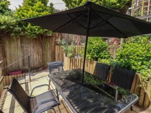 a table and chairs with an umbrella on a patio at Treveline in Bodmin