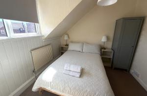 a bedroom with a bed with two towels on it at Avalon Lodge in Bridlington