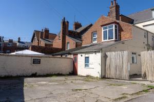 an old brick house with a fence in front of it at Avalon Lodge in Bridlington
