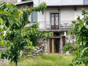 a house with a porch and a balcony at Maison à la coque in Baceno