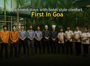 a group of men standing in front of a building at Perfectstayz Premium Carnival Suites Near Candolim in Pilerne