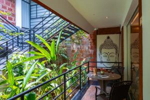 a balcony with a table and some plants at Avocado Cottages by Alaya Stays, Coorg in Suntikoppa