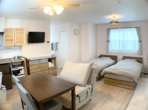 a living room with two beds and a table at Alaula in Izumi-Sano