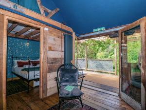 a room with a bed and a chair on a wooden deck at Ferryman's Lodge in Chepstow