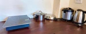 a table with pots and pans and a laptop on it at Staypineapple in Quy Nhon