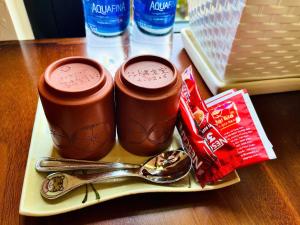 two cups of chocolate sauce on a plate with spoons at Staypineapple in Quy Nhon