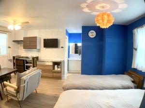 a bedroom with two beds and a blue wall at Alaula in Izumi-Sano