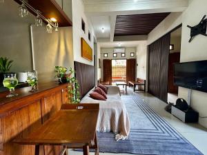 a living room with a bed and a tv at Villa Kecombrang in Salakan