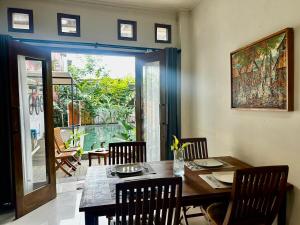 a dining room with a table and chairs and a window at Villa Kecombrang in Salakan