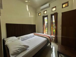 a bed sitting in a bedroom with a window at Villa Kecombrang in Salakan +14 photos