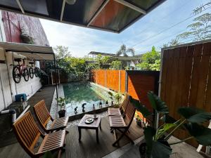 a patio with a pool and two chairs and a table at Villa Kecombrang in Salakan