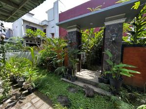 a garden with a cat sitting in front of a building at Villa Kecombrang in Salakan