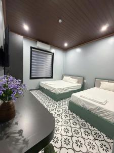 a bedroom with two beds and a table and flowers at Bông Phố Cổ Homestay in Ninh Binh