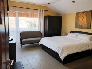 a bedroom with a bed and a chair and a window at Vis de Primăvară, vilă întreagă cu 4 dormitoare și vedere la lac in Limanu