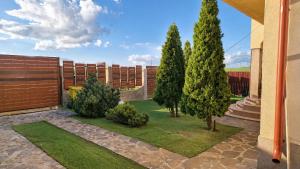 a garden with trees and a fence and grass at Vis de Primăvară, vilă întreagă cu 4 dormitoare și vedere la lac in Limanu
