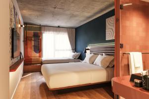 a bedroom with two beds and a window at Hotel Schani Naschmarkt - opening September 2026 in Vienna