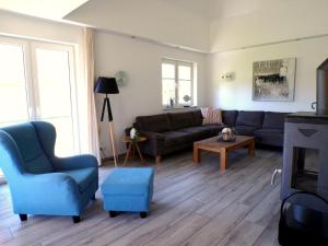 a living room with a couch and a blue chair at Reetdachhaus 3, inkl 2 Parkplätze in Fehmarn