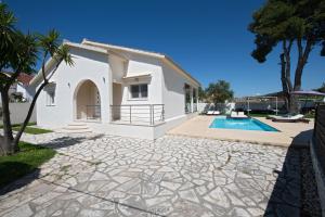a villa with a swimming pool and a house at Beach Villa Christina by PosarelliVillas in Acharavi