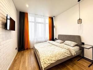 a bedroom with a bed and a large window at Kamanina Lux Apartment in Odesa