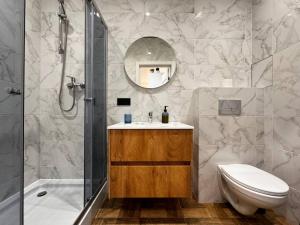 a bathroom with a shower and a toilet and a sink at Kamanina Lux Apartment in Odesa