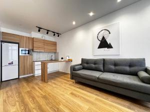 a living room with a couch and a kitchen at Kamanina Lux Apartment in Odesa