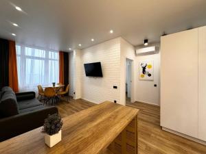 a living room with a couch and a table at Kamanina Lux Apartment in Odesa