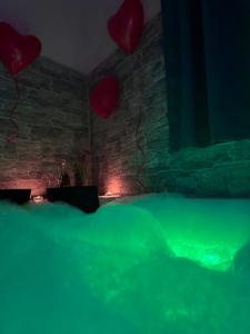 a room with a green bed and red balloons at La Mora Rooms in Linguaglossa