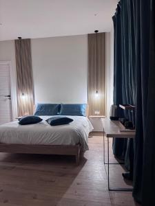 a bedroom with a bed with blue pillows on it at La Mora Rooms in Linguaglossa