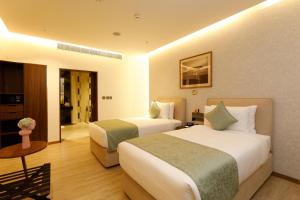 a hotel room with two beds and a table at 080 Transit Hotel, T2 in Bangalore +16 photos
