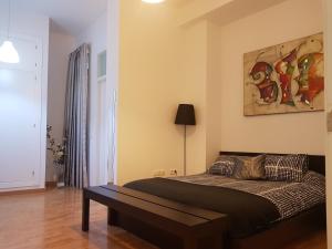マラガにあるApartamento Montaño 4 2 dormitorios y 2 Bañosのベッドルーム1室(ベッド1台付)が備わります。壁には絵画が飾られています。
