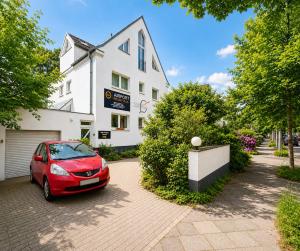 a red car parked in front of a white house at Airport Messe Villa Casa in Düsseldorf
