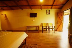a bedroom with a bed and a table and chairs at Entire Farm house in Jim Corbett with staff and cook in Rāmnagar
