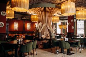 a restaurant with tables and chairs and chandeliers at Gasthaus & Spa Bukovel in Bukovel