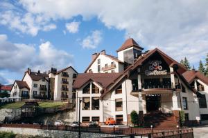 a large building with a restaurant on a hill at Gasthaus & Spa Bukovel in Bukovel