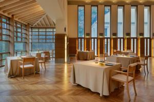 ein Restaurant mit Tischen und Stühlen und großen Fenstern in der Unterkunft Gran Hotel – Balneario de Panticosa in Panticosa