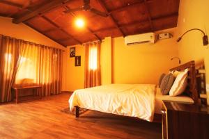 a bedroom with a bed in a room with yellow walls at Entire Farm house in Jim Corbett with staff and cook in Rāmnagar