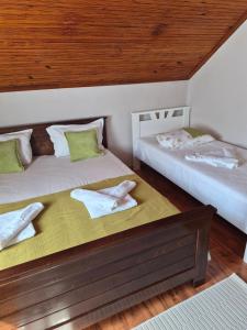 two twin beds in a room with wooden ceilings at Apartment Mirjana in Kotor