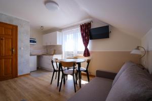 a living room with a couch and a table and a kitchen at Chata Jana in Łeba