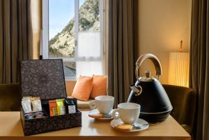 ein Tisch mit einem Teekessel und zwei Tassen darauf in der Unterkunft Gran Hotel – Balneario de Panticosa in Panticosa