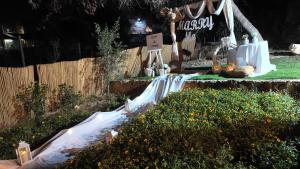 a garden with a table with flowers and a sign at צלילי המעיין- צימר בוטיק במדבר in Arad