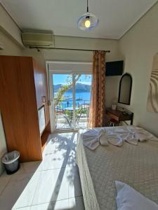 una camera da letto con un grande letto e una grande finestra di Babis a Città di Skiathos