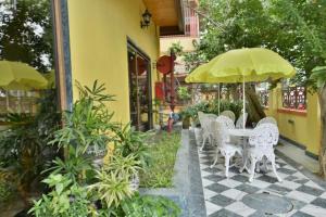 a table and chairs with umbrellas on a patio at Eennra Oiitijhyya in Kolkata +21 photos