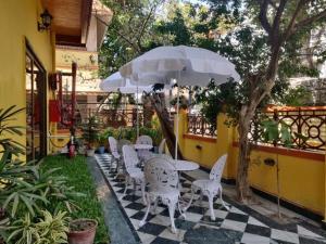 a patio with a table and chairs and an umbrella at Eennra Oiitijhyya in Kolkata