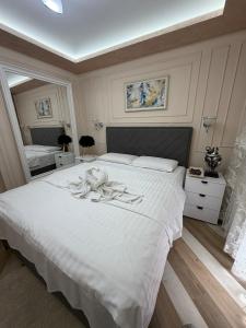 a bedroom with a large white bed with white sheets at LuxHouseNiksic in Nikšić +24 photos