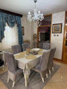 a dining room table with chairs and a chandelier at LuxHouseNiksic in Nikšić