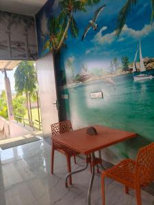 a room with a table and chairs and a mural at Amrit hotel & resort in Nārāyanpur