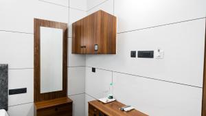 a bathroom with a mirror and a wooden cabinet at Sreebhadra Residency in Chavara +45 photos